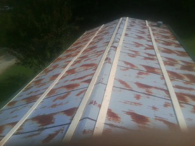 Rusted metal roof panels with new wood purlins before replacement — Storm Damage Roof Repair in New Era by Roofing Brothers