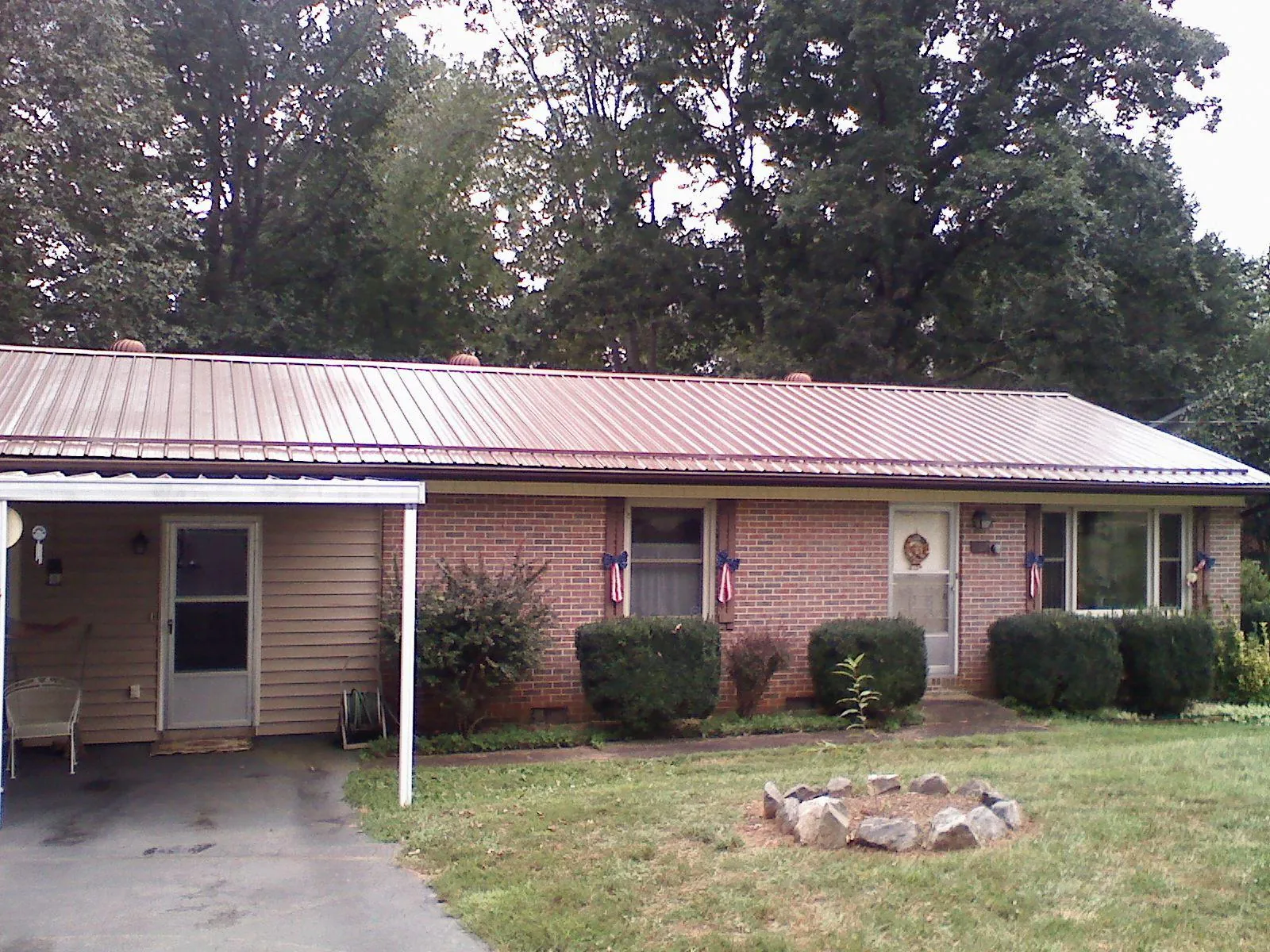 Bronze metal roof and carport on a brick ranch home — Roof Repair work by our crew in New Era
